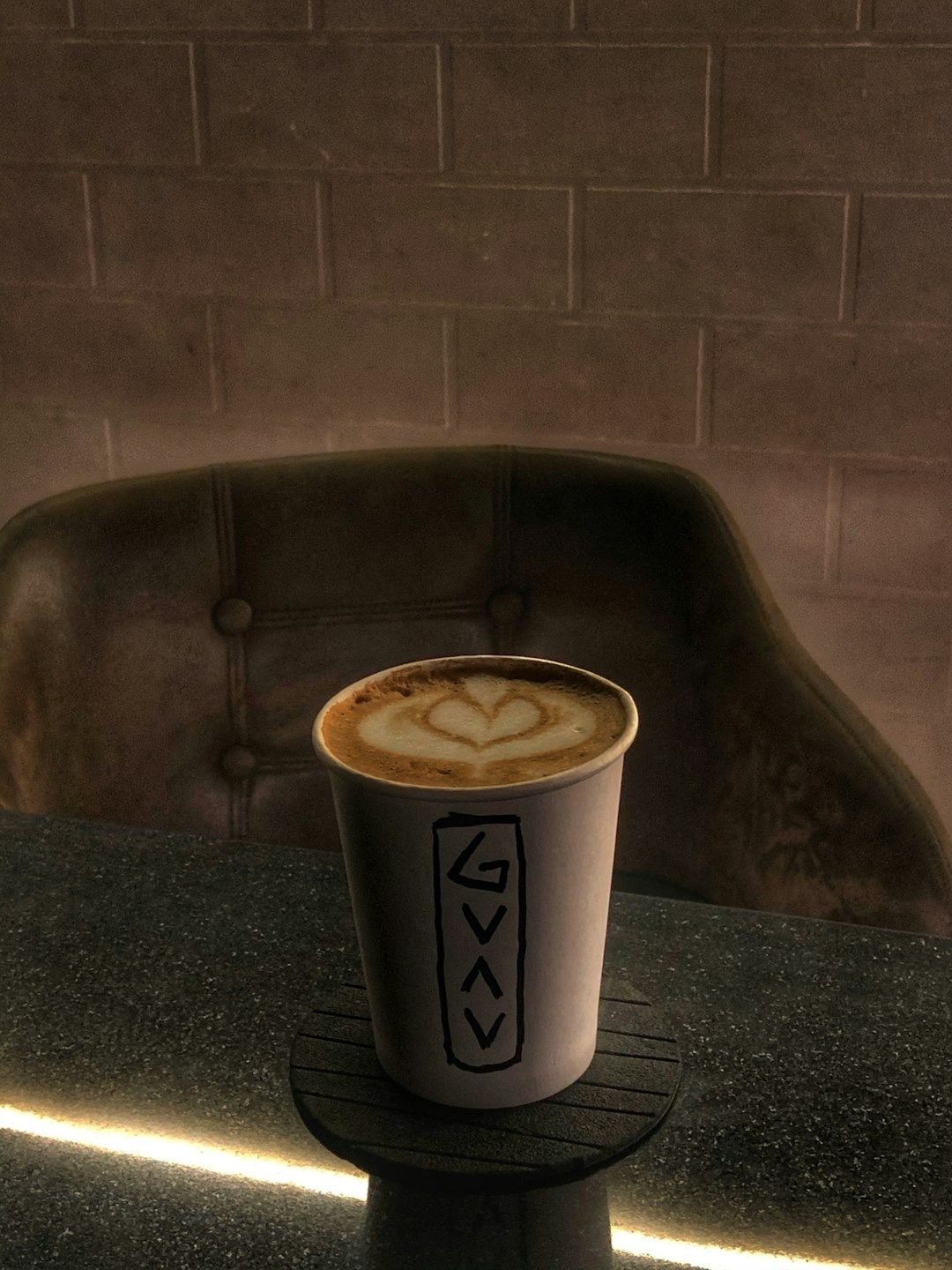 Latte with foam art in a paper cup
