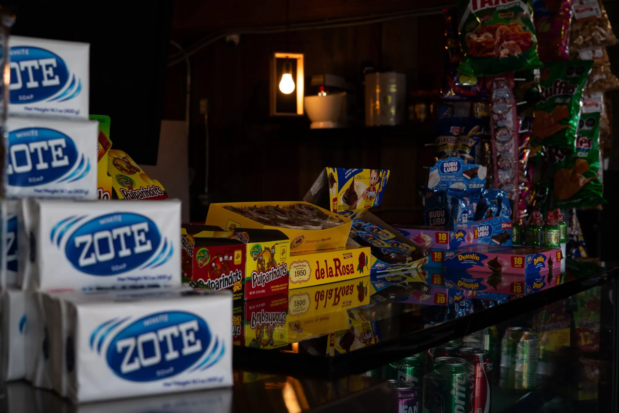 Stacks of Zote soap beside open boxes of de la Rosa mazapán, Pulparindots, Duvalín and Bubulubu on the shop counter